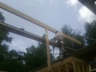 Carpenter setting a ridge beam over a new addition frame — Ice Dam Removal by Roofing Brothers in Wood River