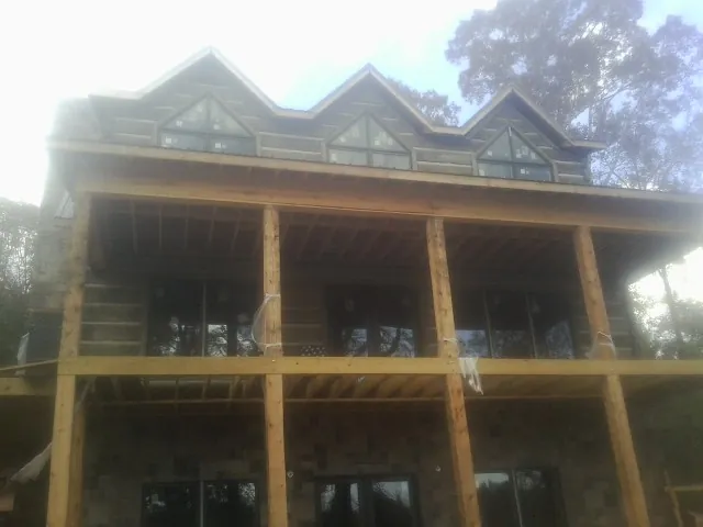 Dormers and porch framing on a large log home under construction — Roof Coating work by our crew in Wood River