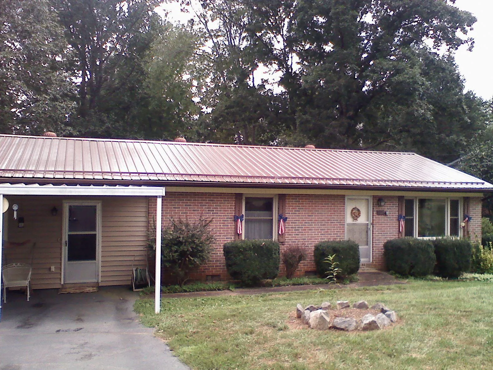 Bronze metal roof and carport on a brick ranch home — Roof Repair work by our crew in Wood River